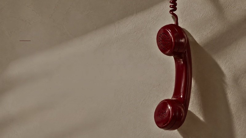 Telefone vermelho pendurado pelo fio
